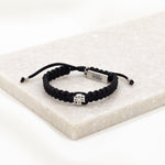 black cording woven slip knot bracelet with silver tone medal and silver tone faith tag