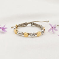 Tan cording, slipknot closure, gold and silver tone floral medals