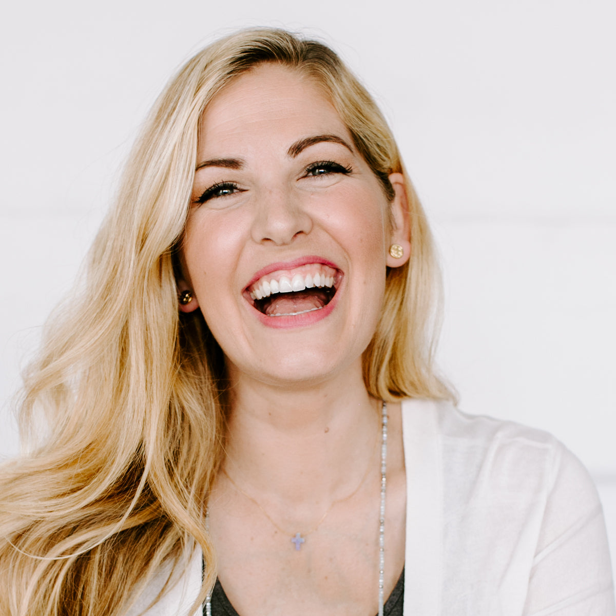 Woman laughing wearing gold tone Benedictine Stud Earrings