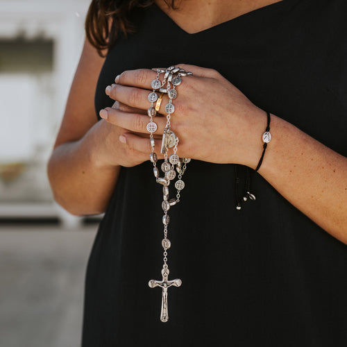 Benedictine Medjugorje Rosary held by a woman in a black dress
