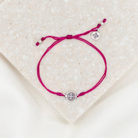 silver-tone St. Benedict medal on maroon bracelet cording with a slipknot closure