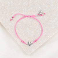 silver tone St. Benedict medal on pink bracelet cording with a slipknot closure