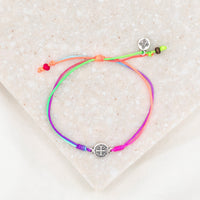 silver-tone St. Benedict medal on rainbow colored bracelet cording with a slipknot closure