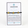 Gratitude St. Benedict Blessing Bracelet on customizable gifting card, gold tone St. Benedict Medals and black crystals