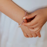 Love Lights the Way for Kids - St. Amos Crystal Pearl Bracelet on young person's wrist
