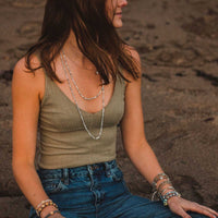 Young woman wearing the Love Morse Code Prayer Rope sitting on beach