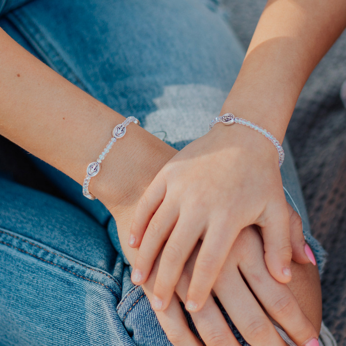 Mother Daughter bead and Miraculous Mary Medal Bracelets close up on a mother's and daughter's wrists