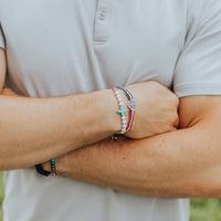 Close up of Man wearing a United in Prayer Gemstone and a Unity Woven Red White and Blue Bracelet