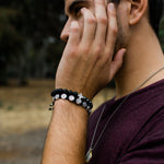 Young Man wearing Perfectly Imperfect Hematite and Lava Bead Handwoven Bracelet with Silver Tone Cross Medal