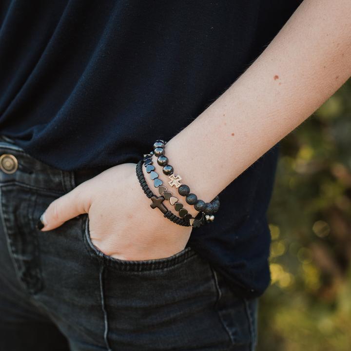 A woman wearing a black themed bracelet stack with howlite and hematite beads from My Saint My Hero
