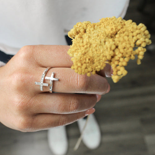a close up of a hand holding yellow flowers and wearing a Pillar of Faith sterling silver and diamond cross ring