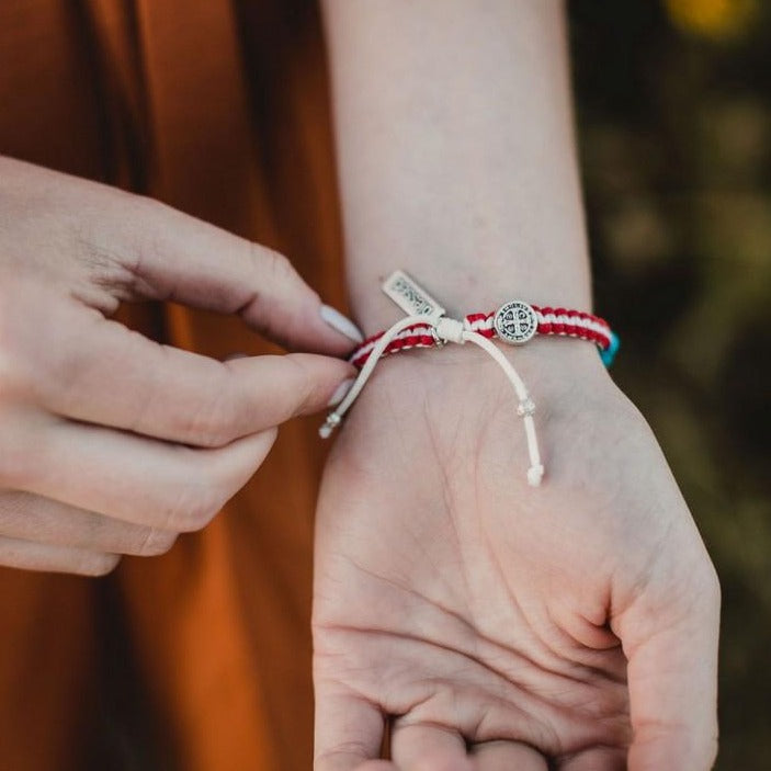 Woman wearing a Protect and Serve Bracelet showing the Benedictine Medal and "blessed" tag near the closure of the Blessing Bracelet
