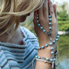 Blonde Woman praying with blue Austrian crystal pearl rosary