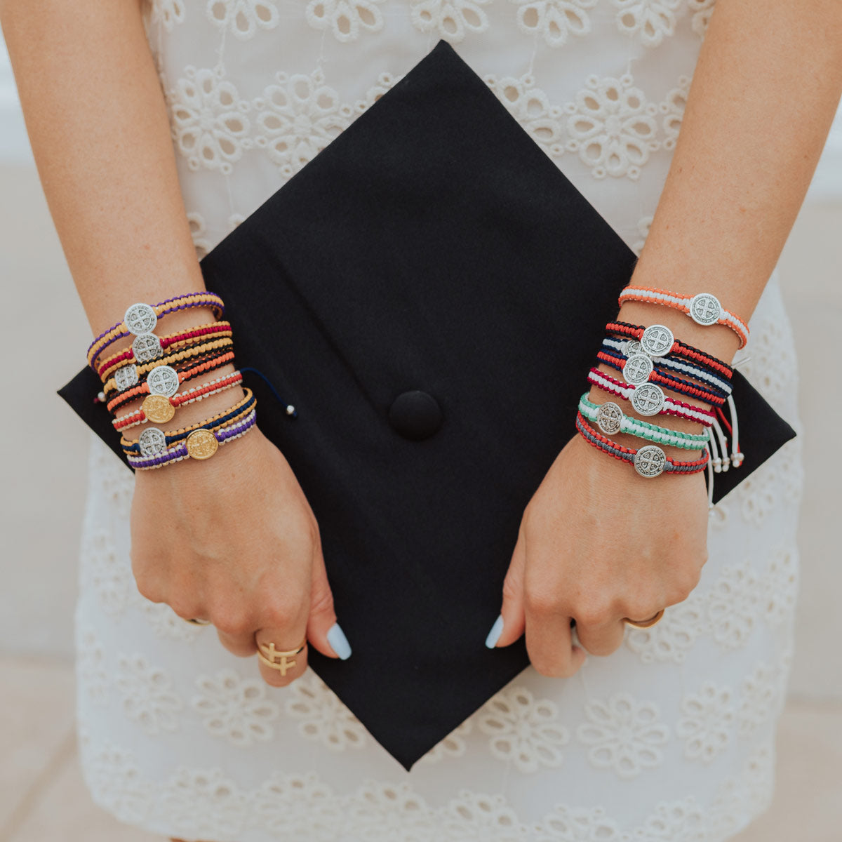 Woman wearing a stack of all the colors of School Spirit handwoven blessing bracelets.