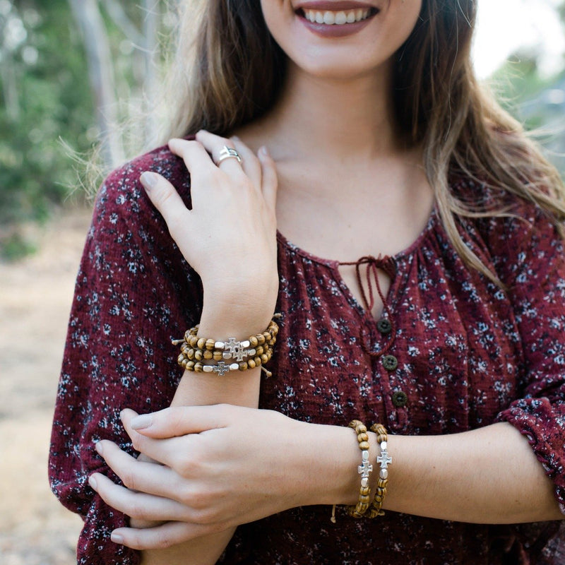 Young women wearing a stack of Rooted in Faith Saint Bracelets
